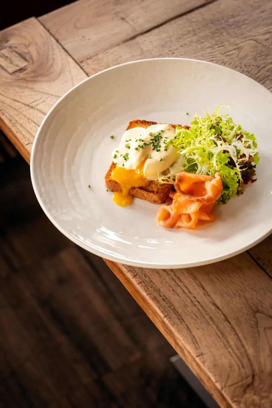 Breakfast table at Café Cihelna — burrata toast, eggs Benedict, waffle and a latte