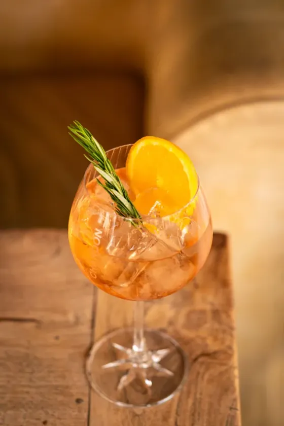 Orange spritz with a slice of orange and rosemary